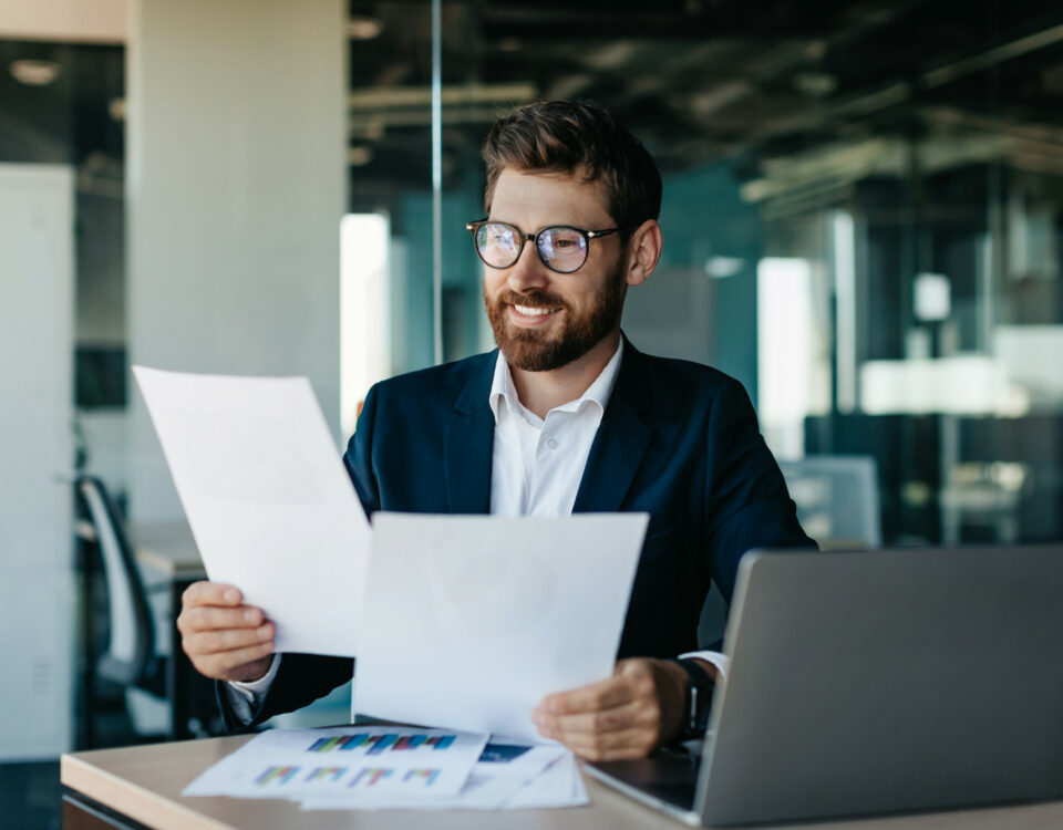 A businessman examining a piece of paper in an office, exploring cross-border e-commerce opportunities.