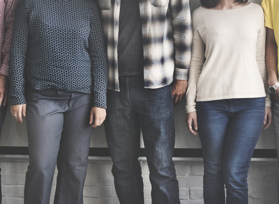 A group of people from different cultural backgrounds standing next to each other, representing the overcoming of cultural barriers in international trade.