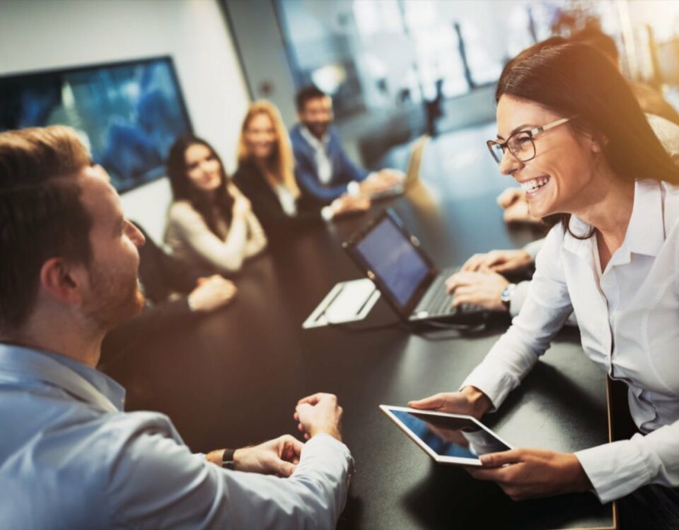 A group of people sitting around a table in a conference room, engaged in localization discussions for customer support.