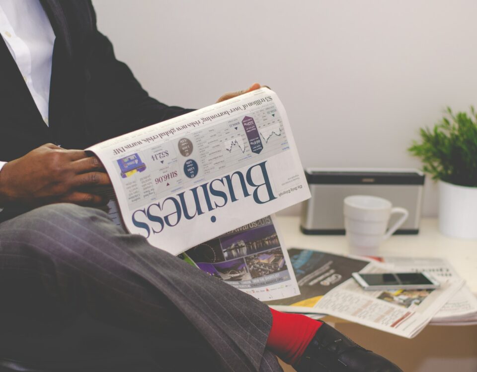 A man in a suit reading a newspaper while exploring export financing options.