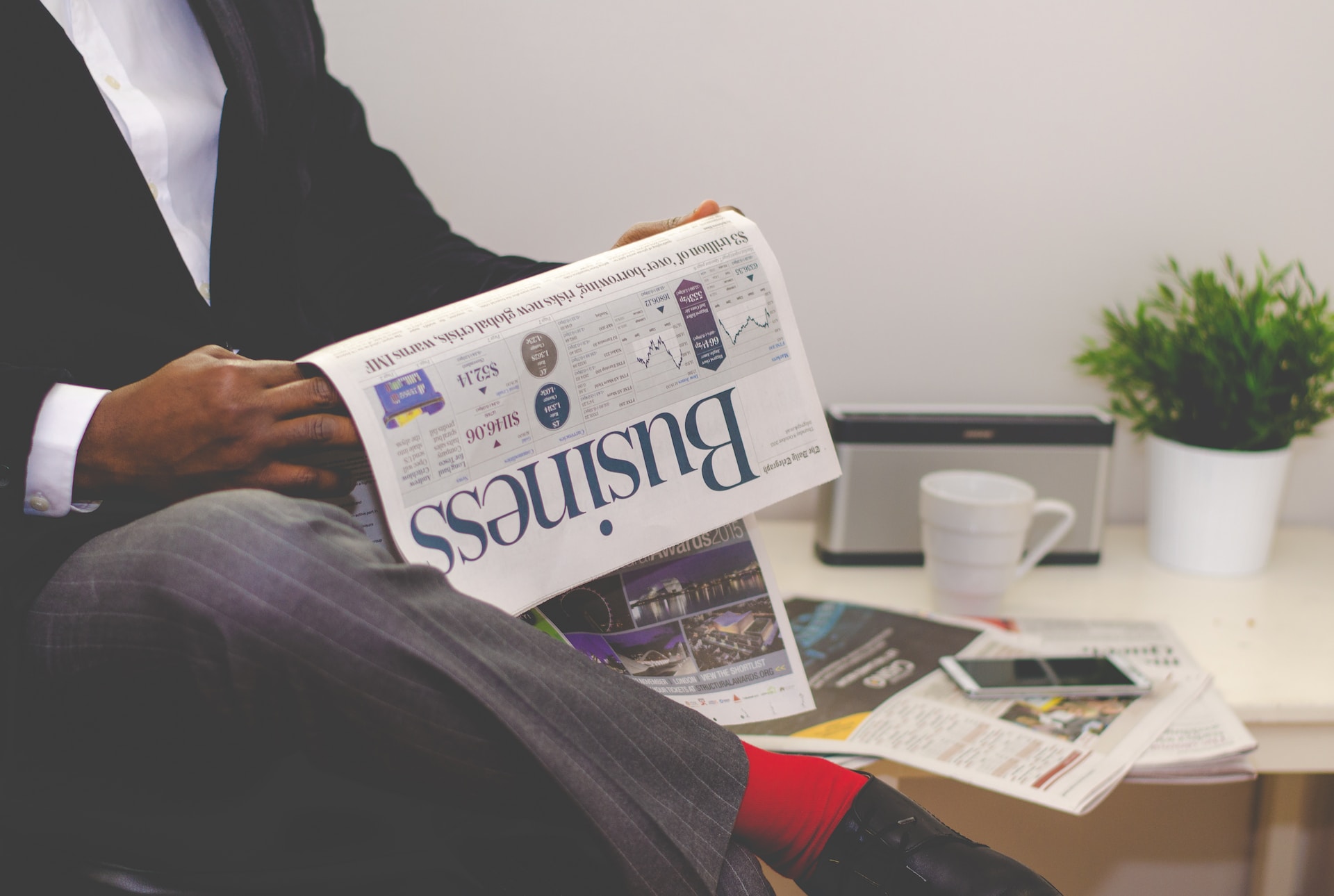 A man in a suit reading a newspaper while exploring export financing options.