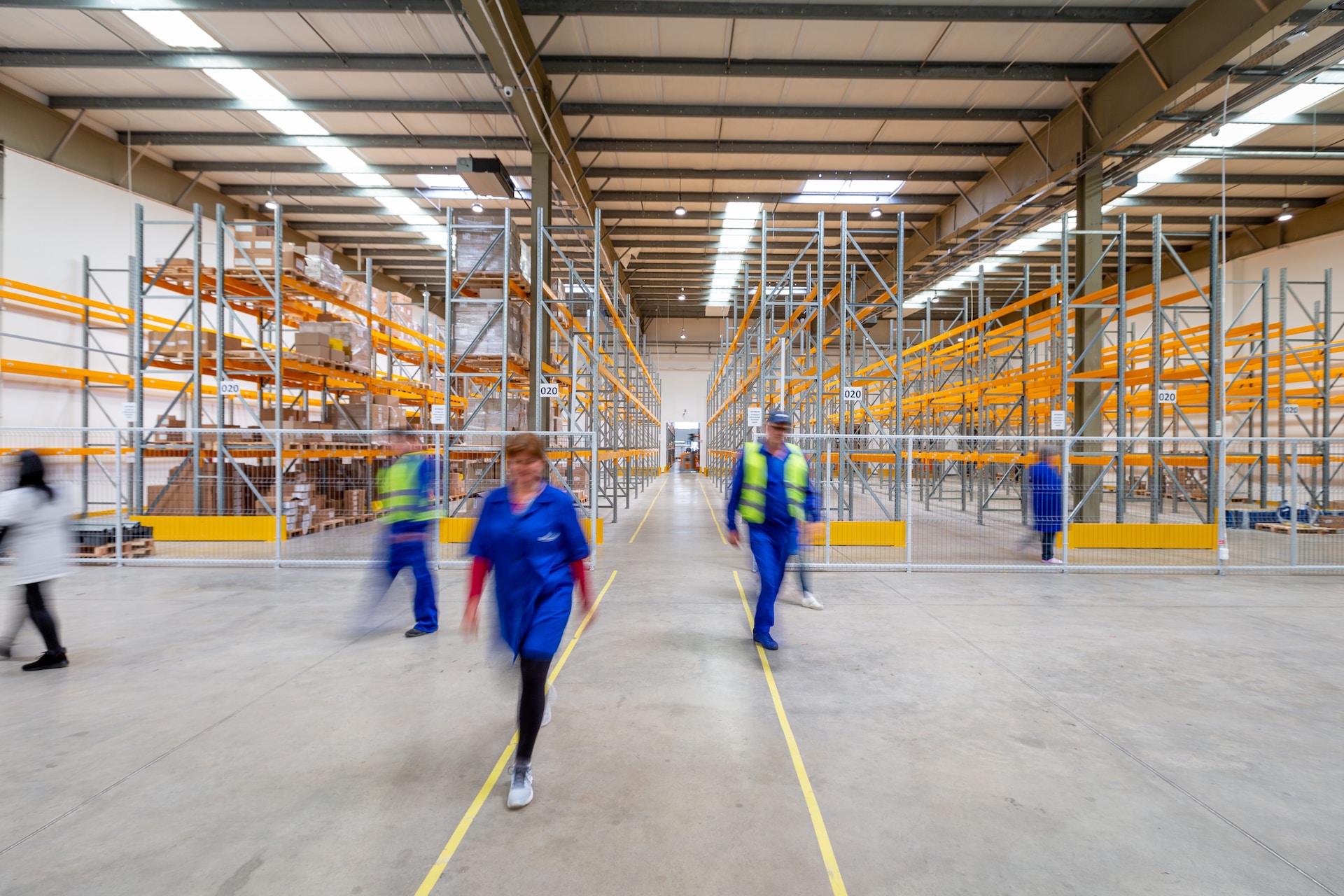 International logistics professionals managing people walking in a warehouse.