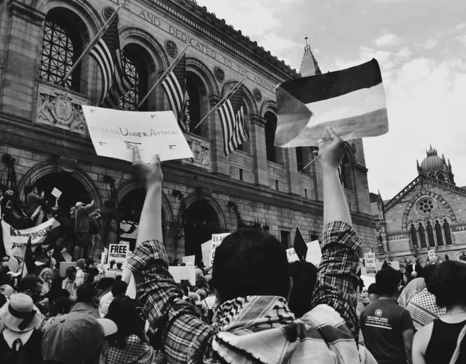 A group of people holding signs in front of a building advocating for intellectual property rights protection.