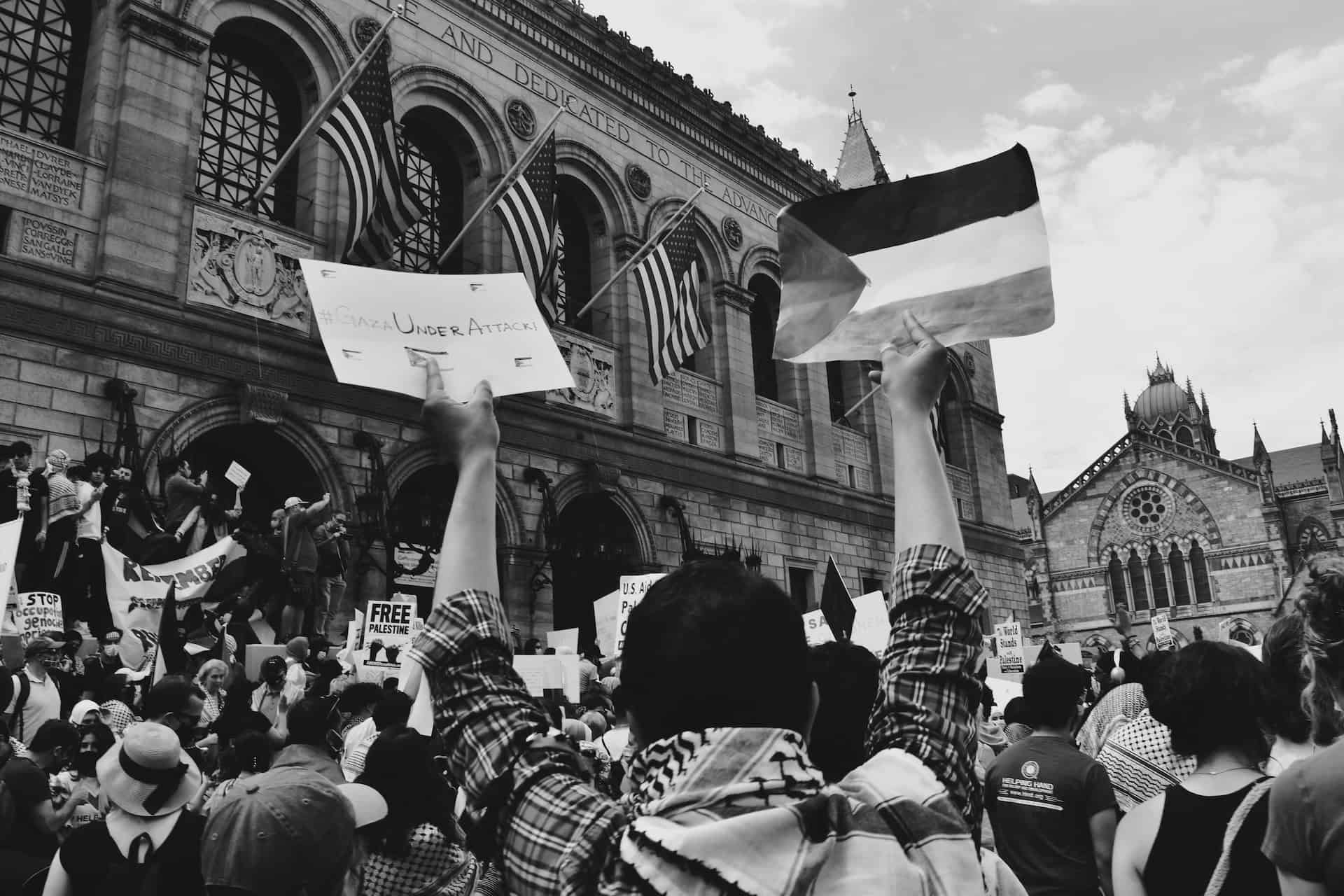 A group of people holding signs in front of a building advocating for intellectual property rights protection.