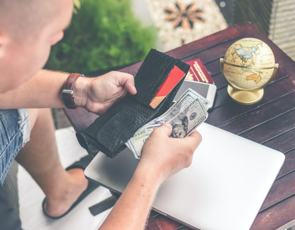 A man is deep diving into international trade financing options with a wallet containing a globe.