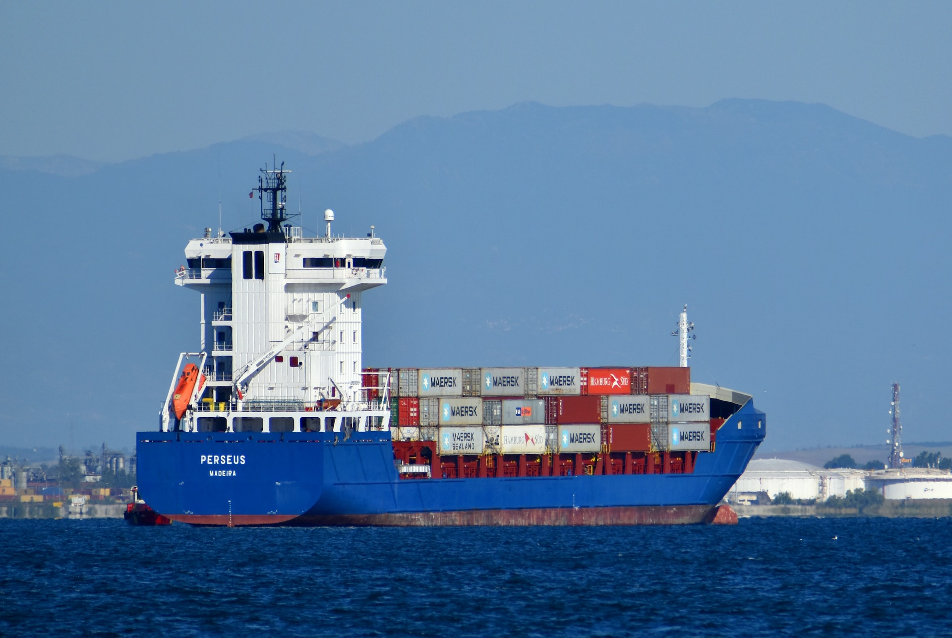 A blue and white container ship complying with international trade regulations.