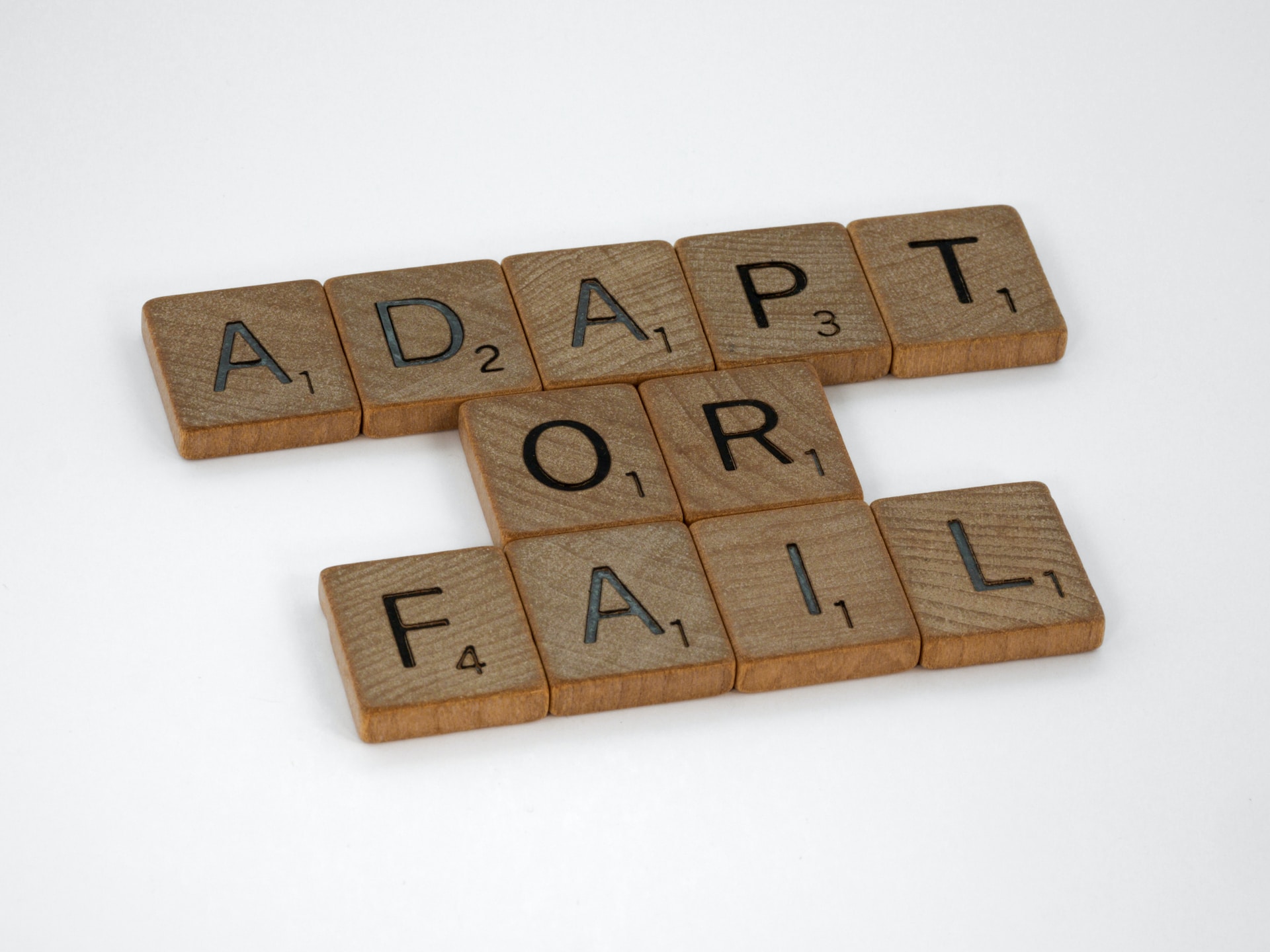 Adapt scrabble tiles on a white background.