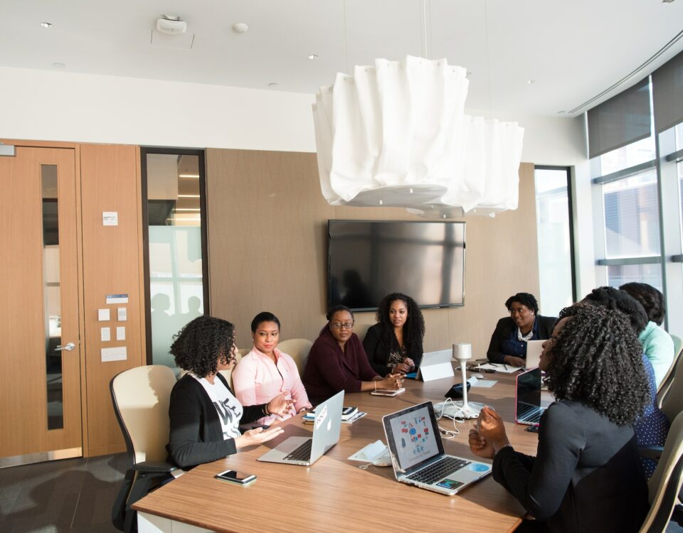 A diverse group of people sitting around a table in a conference room, discussing the benefits of international trade.