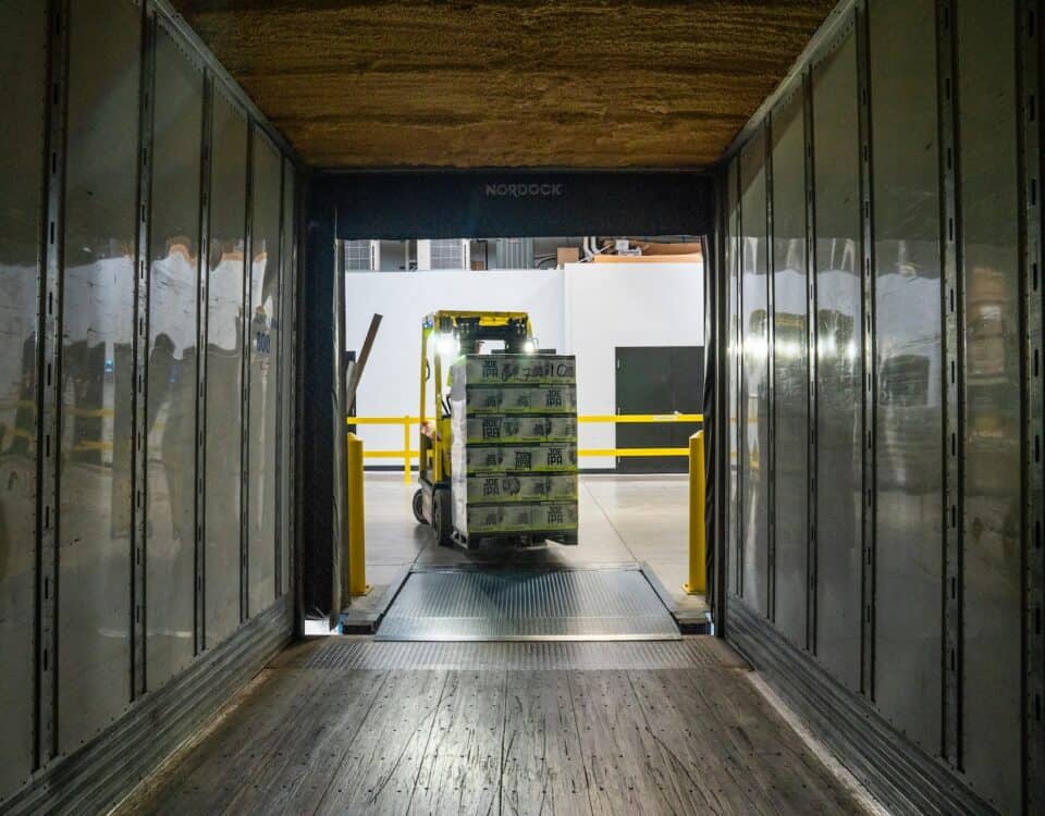 A forklift efficiently driving through a warehouse door, ensuring seamless logistics optimization.