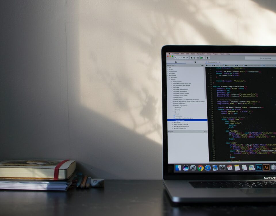 A laptop displaying code on its screen, placed on a desk.