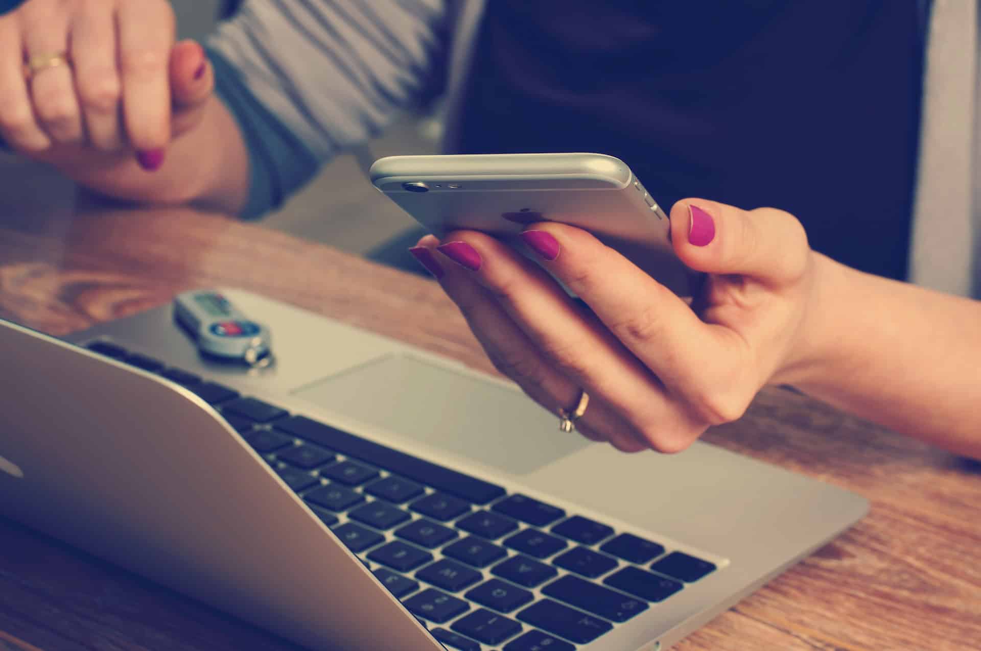 A woman utilizing localization strategies for global markets with a cell phone and a laptop.