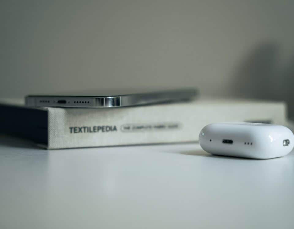 A specific product, the Apple AirPods, sitting on a table next to a book.