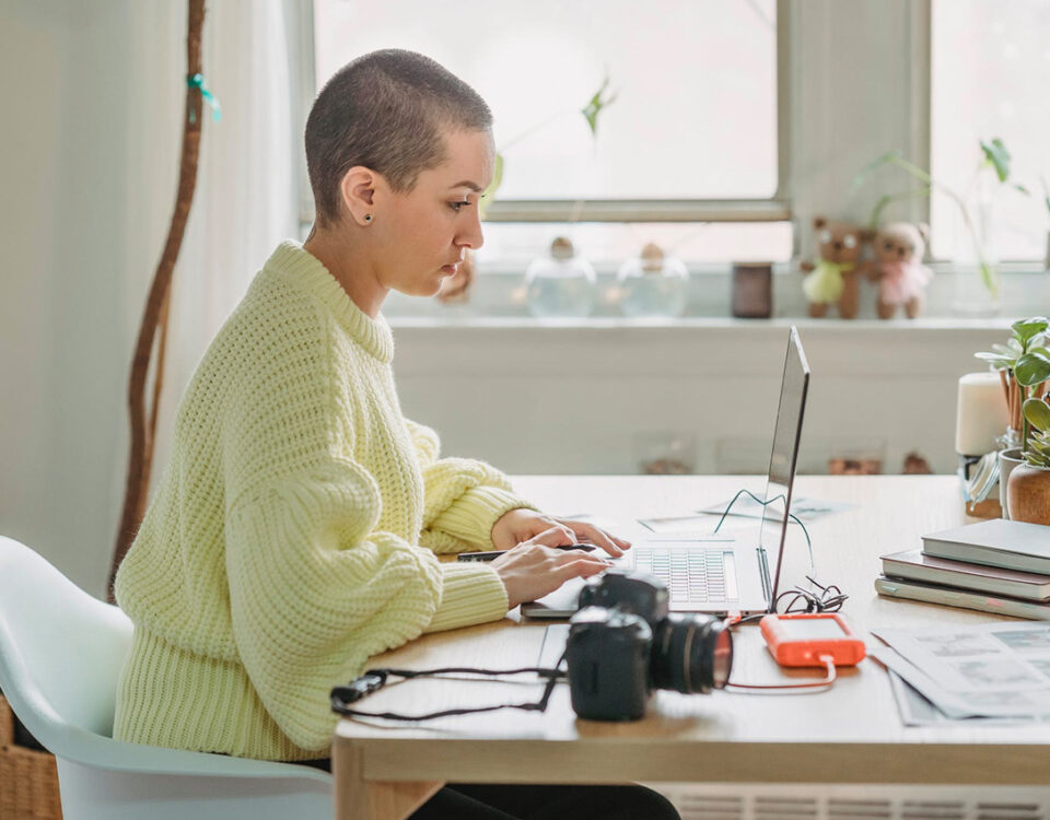 A woman sitting at a desk using a laptop while working on intellectual property rights in the context of international trade.