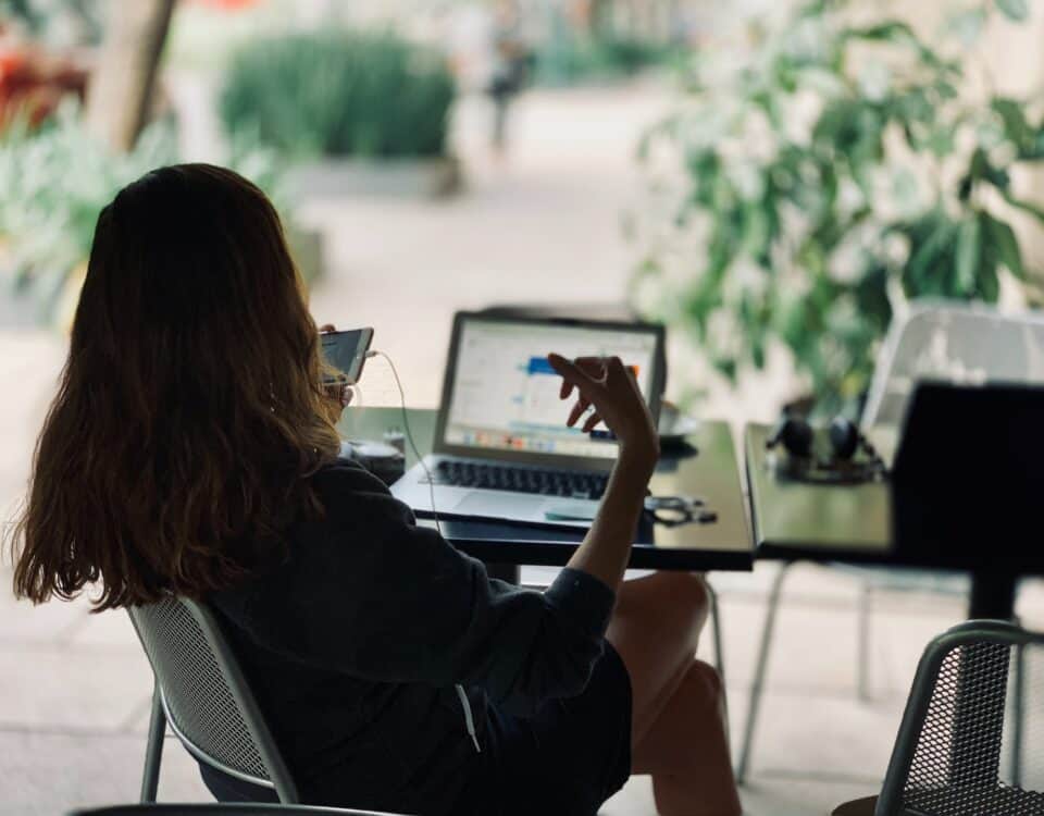 A woman fueling innovation and technological advancement at a table with a laptop.