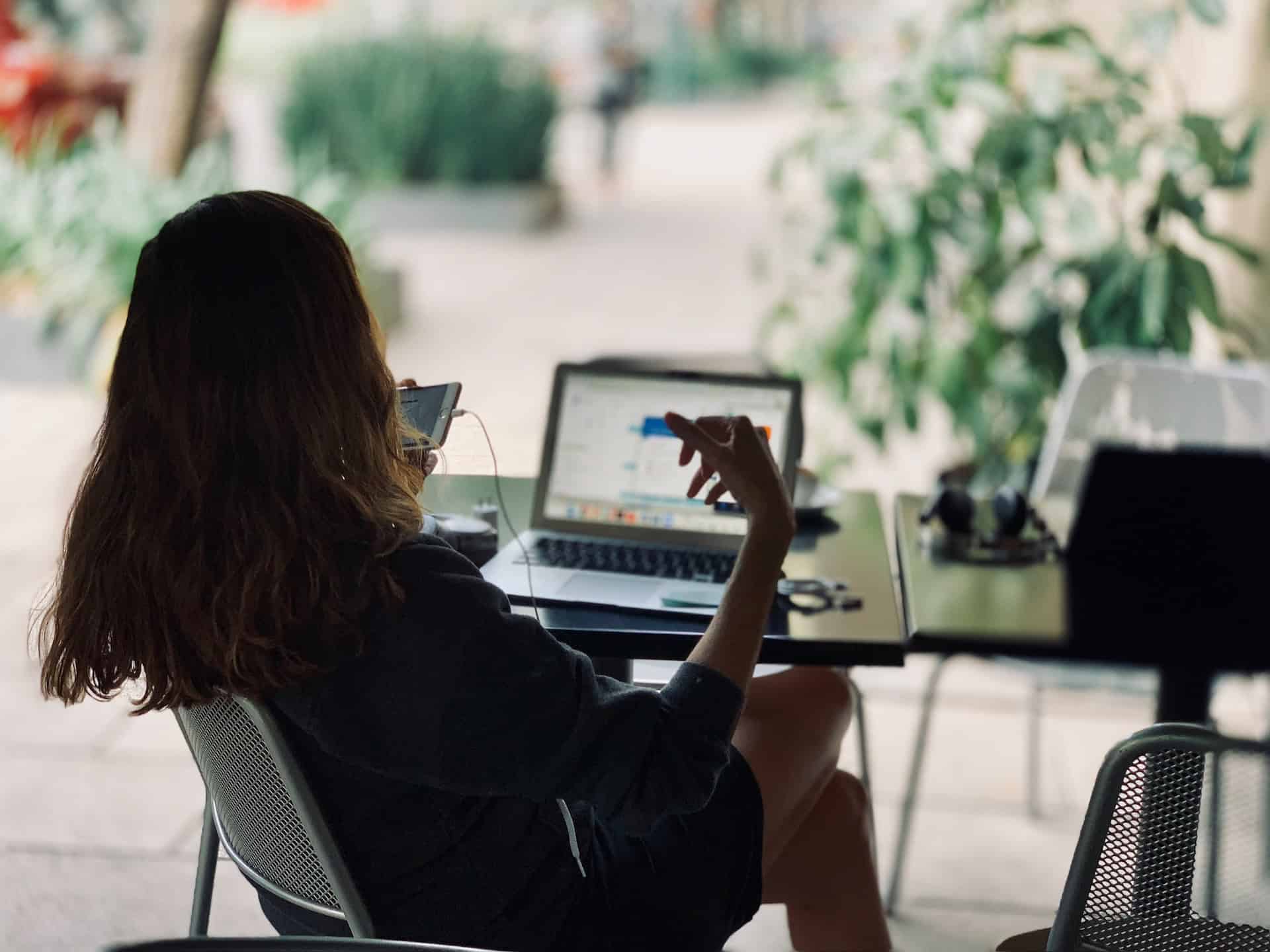 A woman fueling innovation and technological advancement at a table with a laptop.