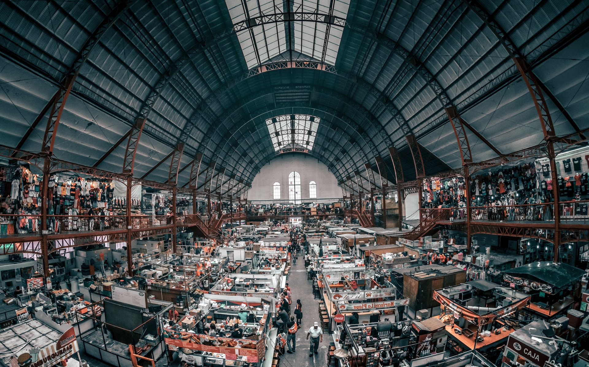 A view of a bustling indoor market with a diverse crowd.