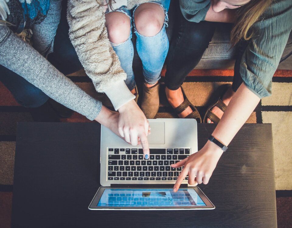 A group of people collaborating on localization efforts for marketing materials, sitting around a laptop.