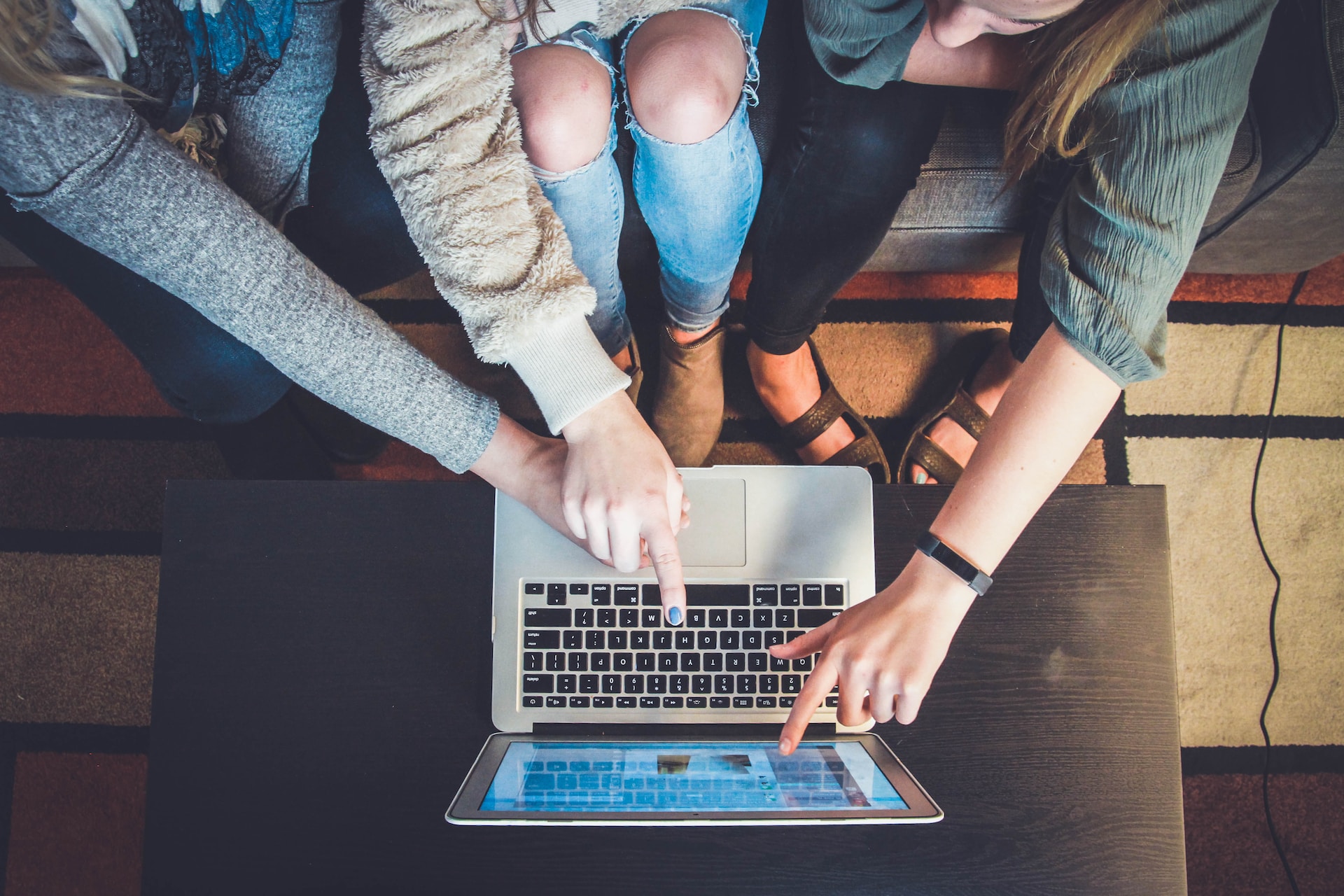 A group of people collaborating on localization efforts for marketing materials, sitting around a laptop.