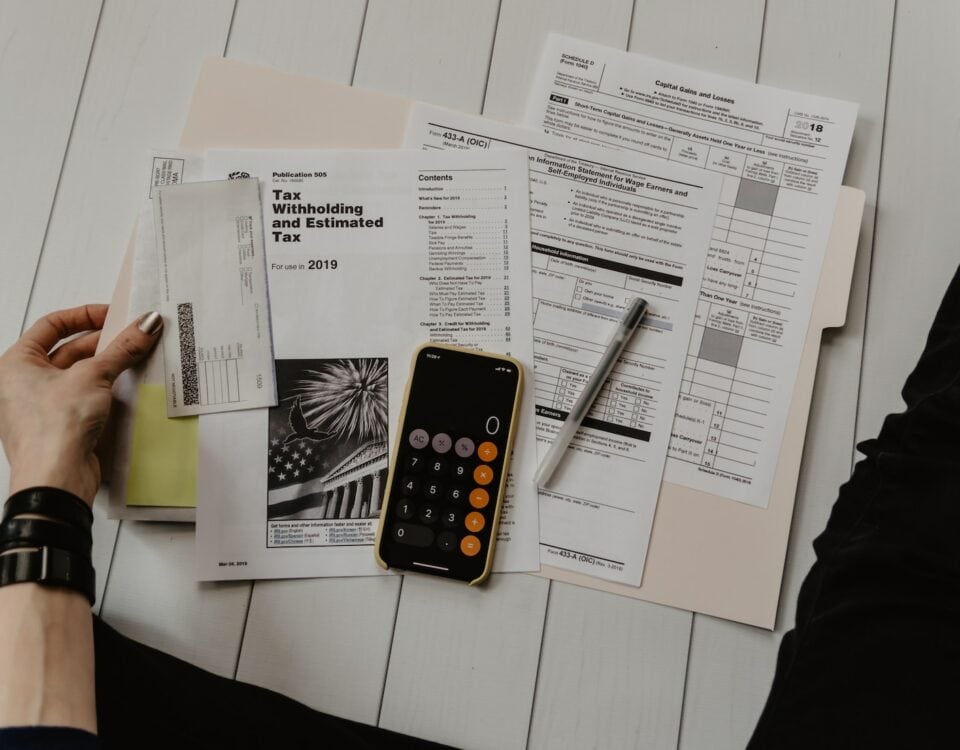 A person sitting on a table with papers and a phone, engaged in export financing for small and medium-sized enterprises (SMEs).