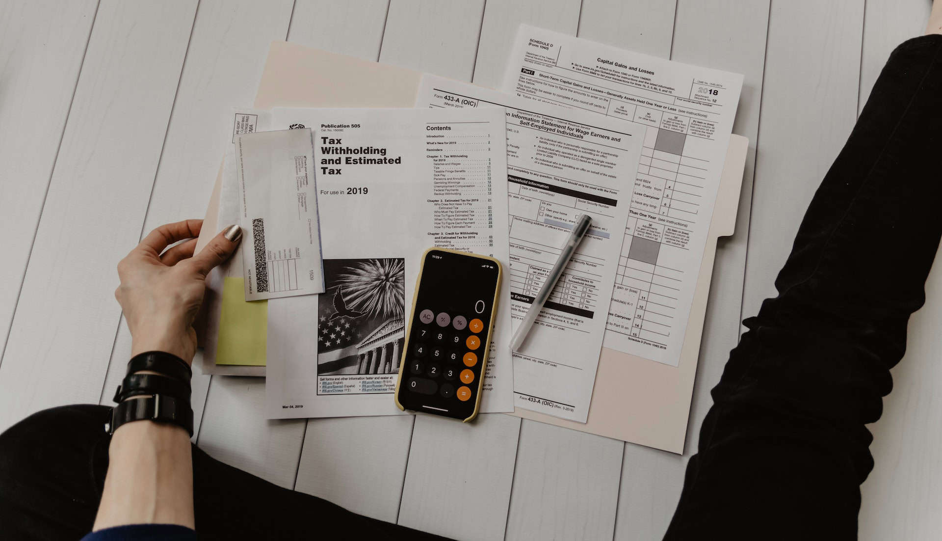 A person sitting on a table with papers and a phone, engaged in export financing for small and medium-sized enterprises (SMEs).