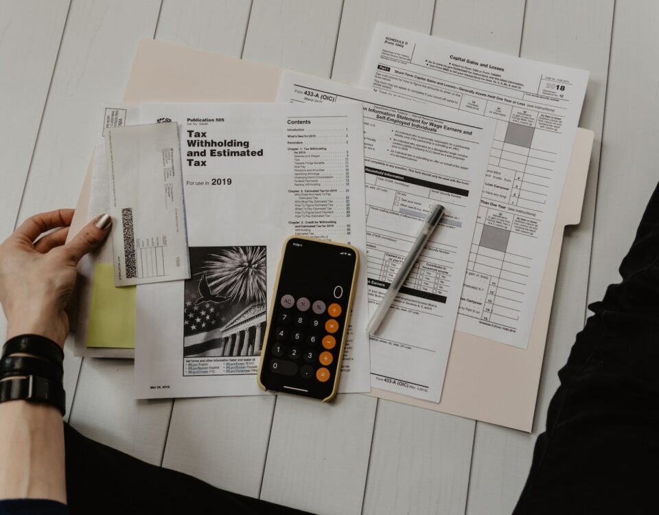 A person sitting on a table with papers, managing export financing and insurance.