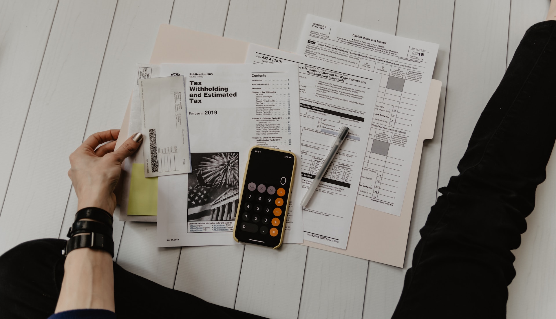 A person sitting on a table with papers, managing export financing and insurance.