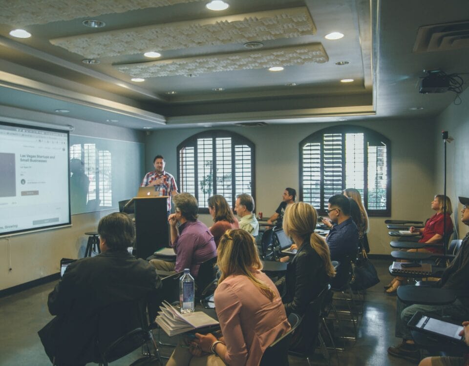 A diverse group of people in a room passionately discussing international trade and challenging protectionism policies while seeking to determine the true value of global economies.