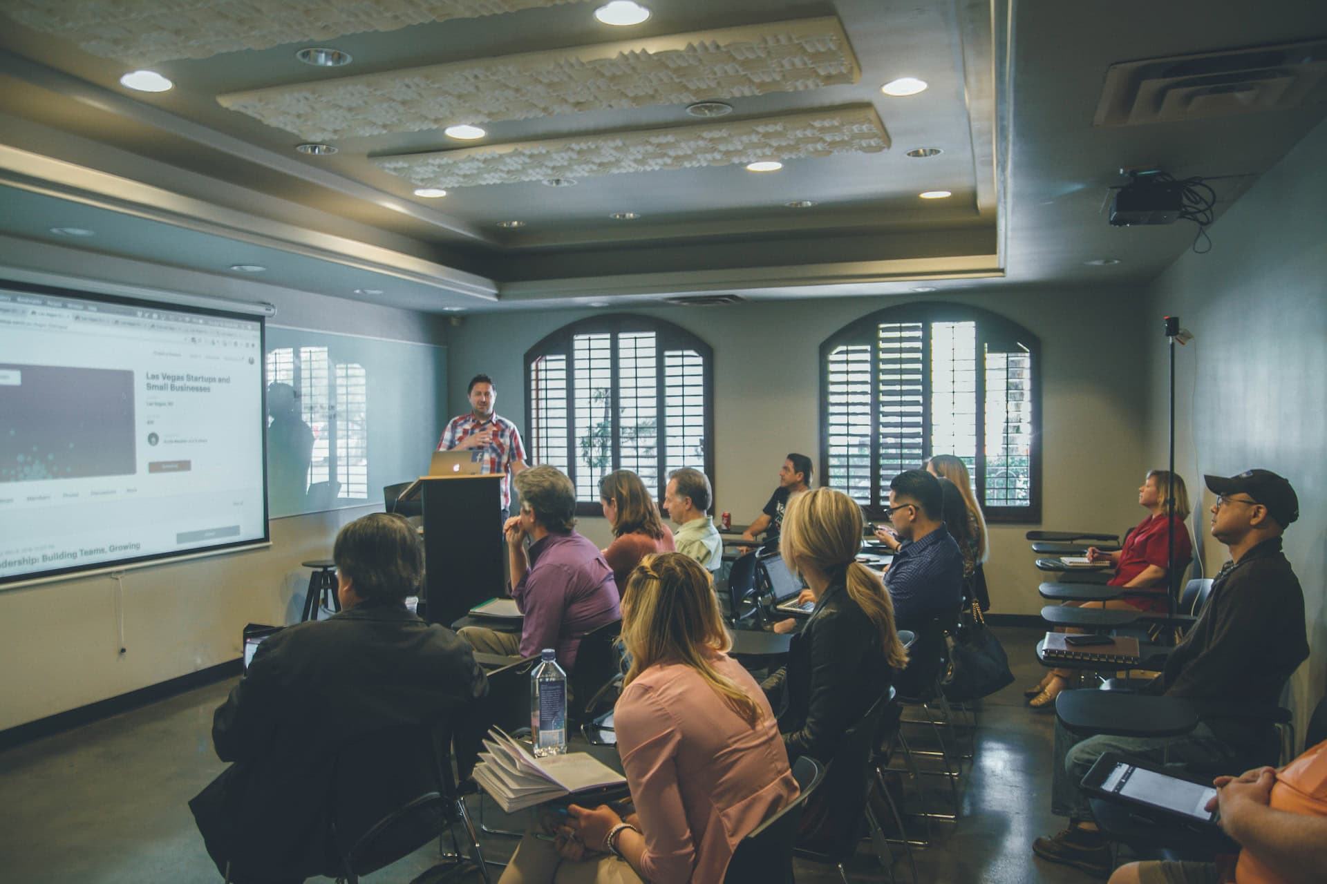 A diverse group of people in a room passionately discussing international trade and challenging protectionism policies while seeking to determine the true value of global economies.