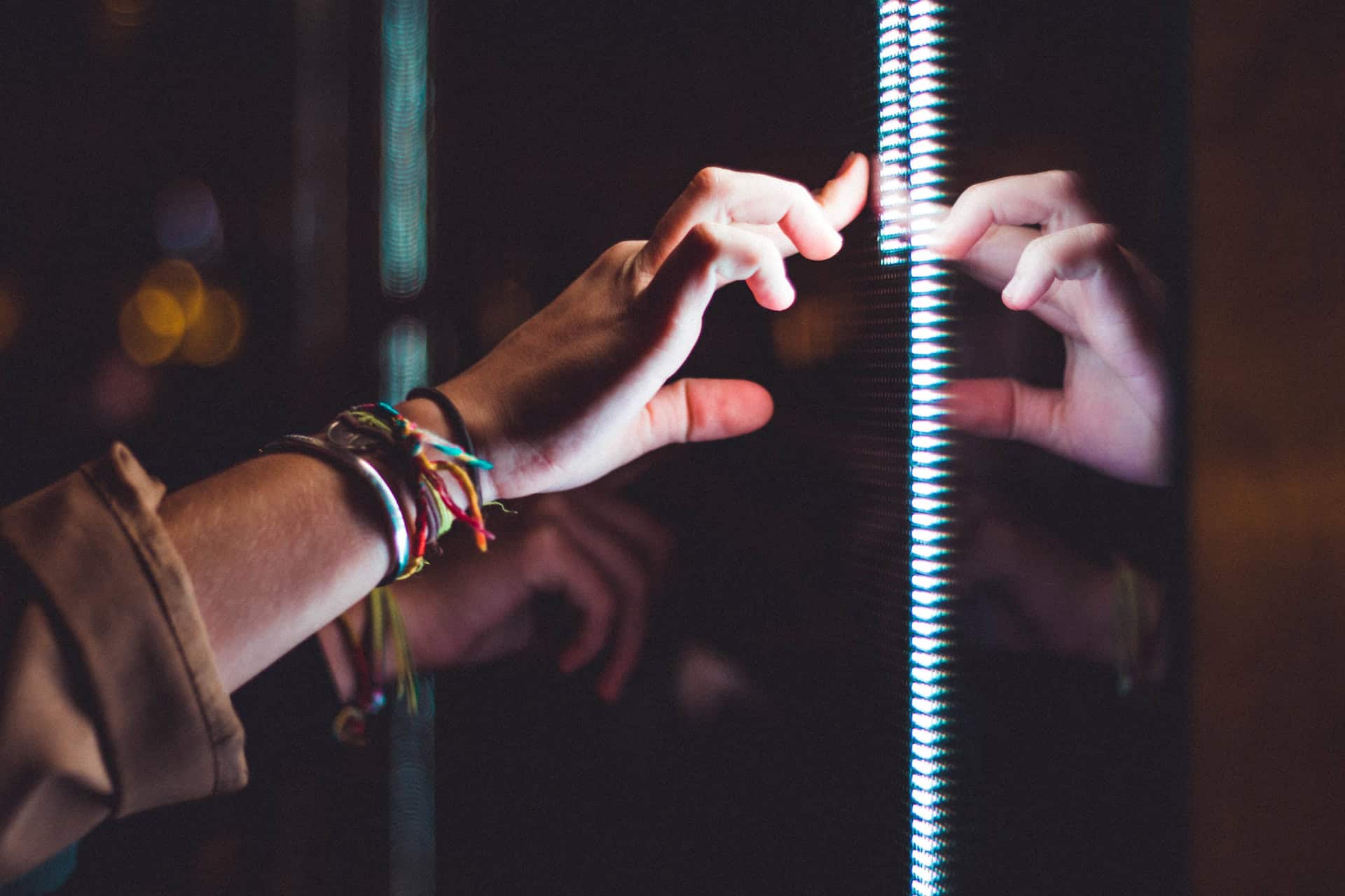 A person's hand reaching into a mirror, symbolizing the transformative role of technology in international trade.