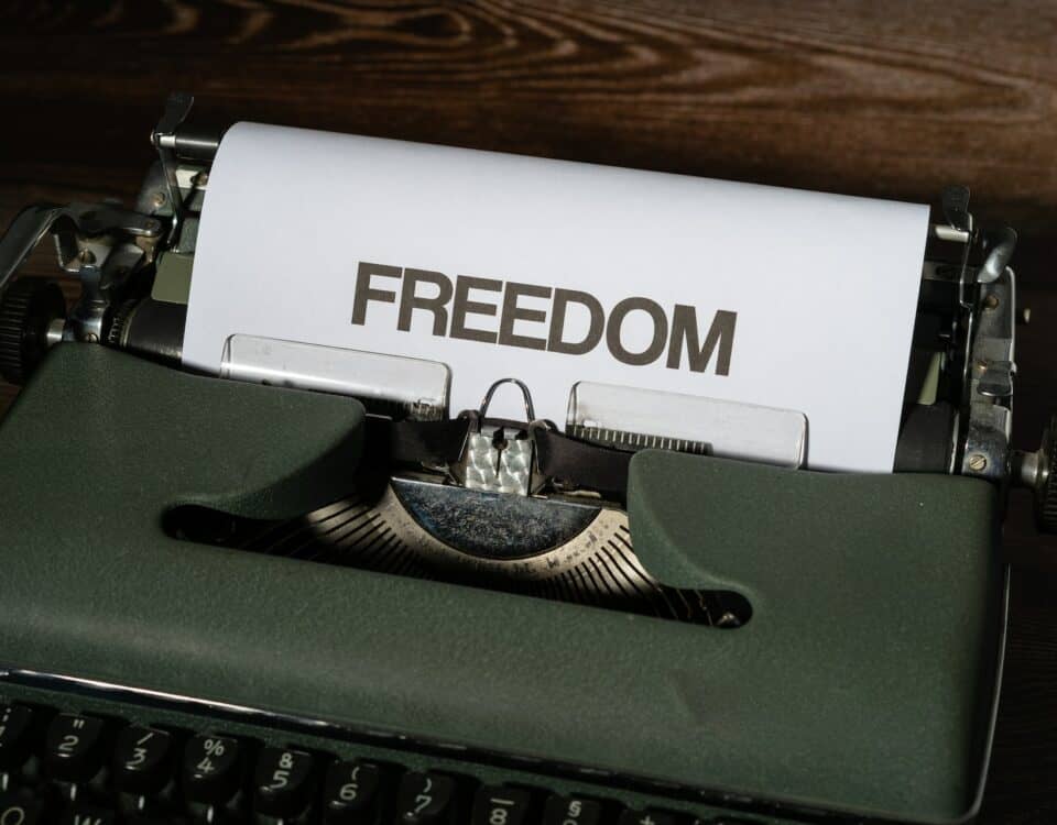 A green typewriter with the word freedom on it, symbolizing economic resilience.