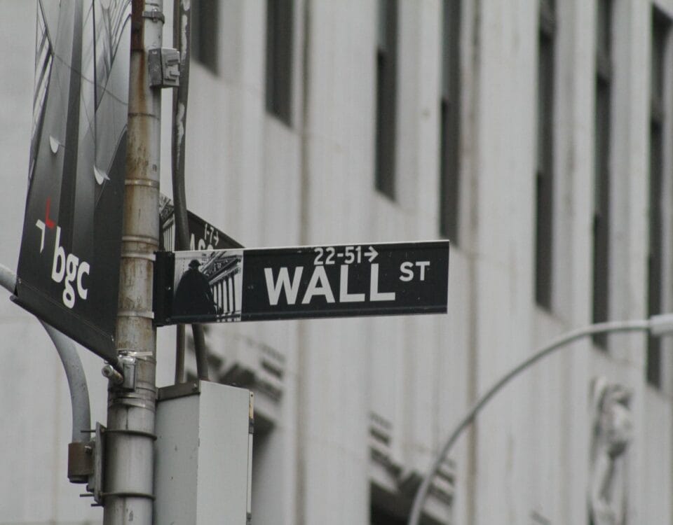 A street sign on a pole in front of a building, representing the economic prosperity of international trade.