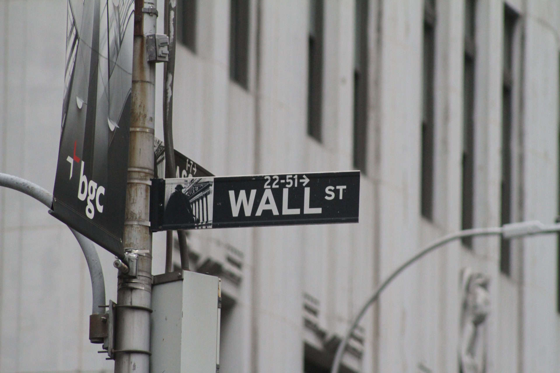 A street sign on a pole in front of a building, representing the economic prosperity of international trade.