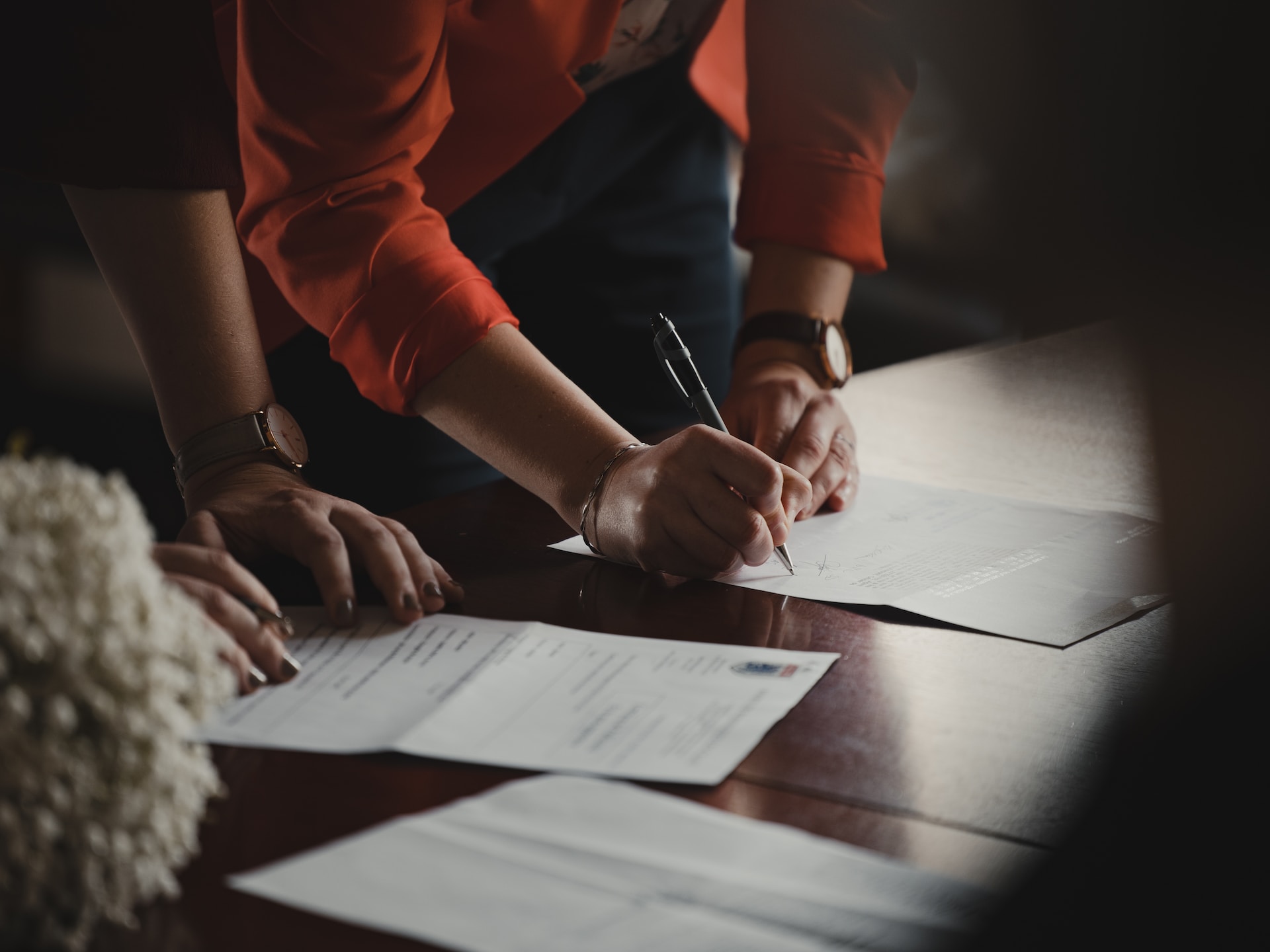 Two people signing export documentation at a table.