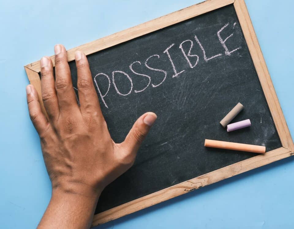 A hand holding a chalkboard with the word possible written on it, showcasing export services.