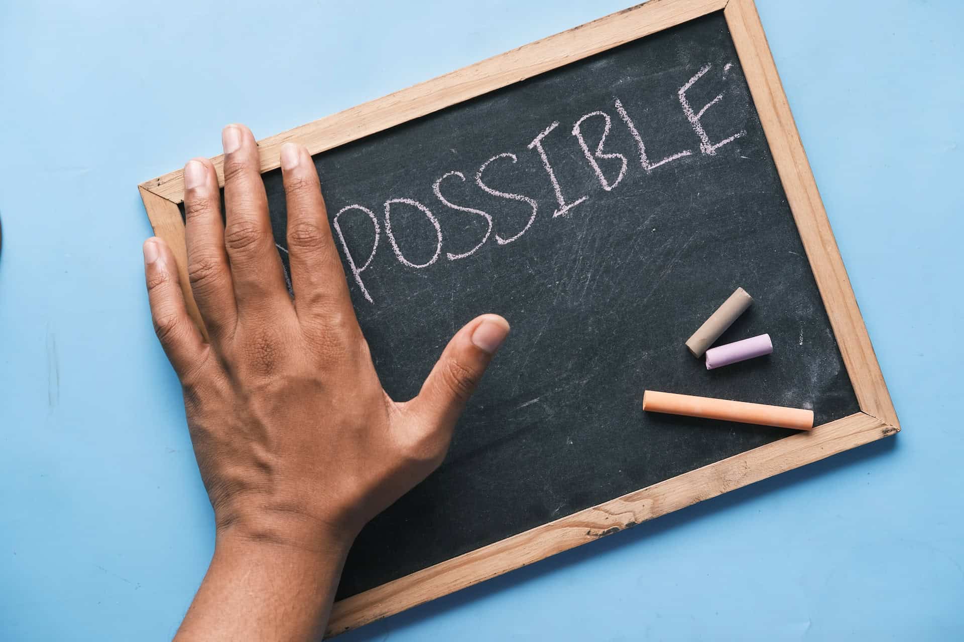 A hand holding a chalkboard with the word possible written on it, showcasing export services.