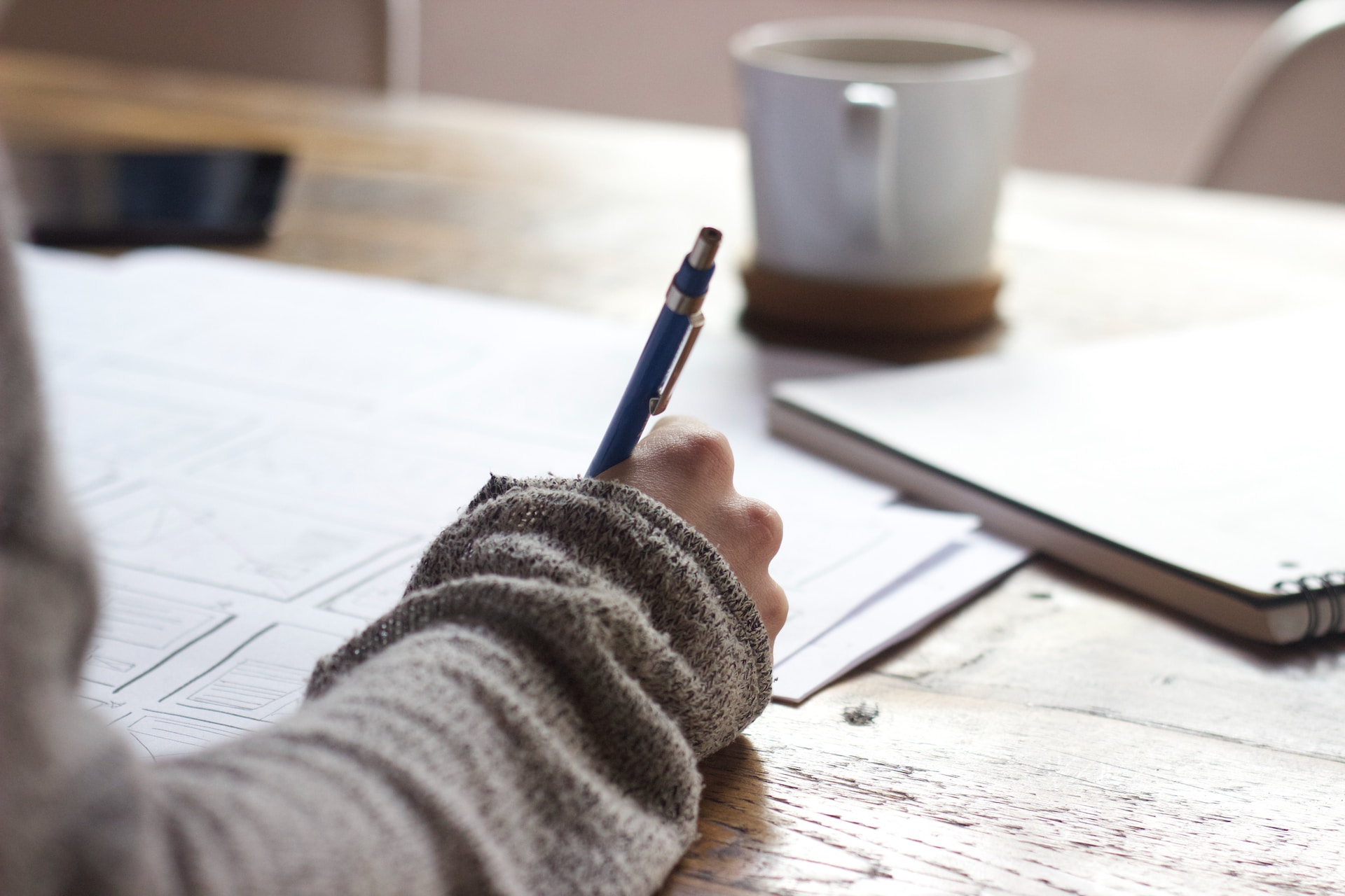 A person writing on a piece of paper at a desk, engaged in business negotiations.