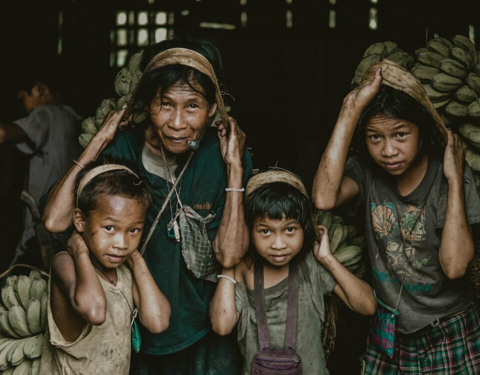 A group of children are holding bananas in their hands, symbolizing the positive impact of international trade on poverty reduction.