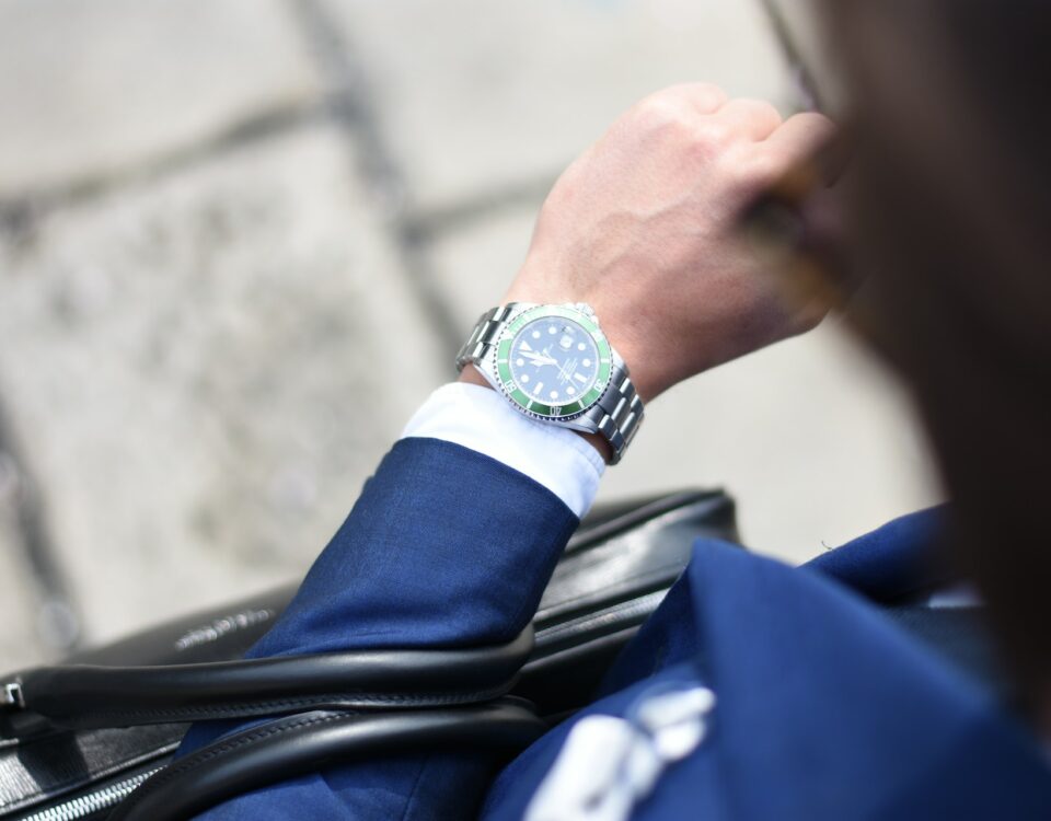 An International Business professional in a suit is wearing a watch.
