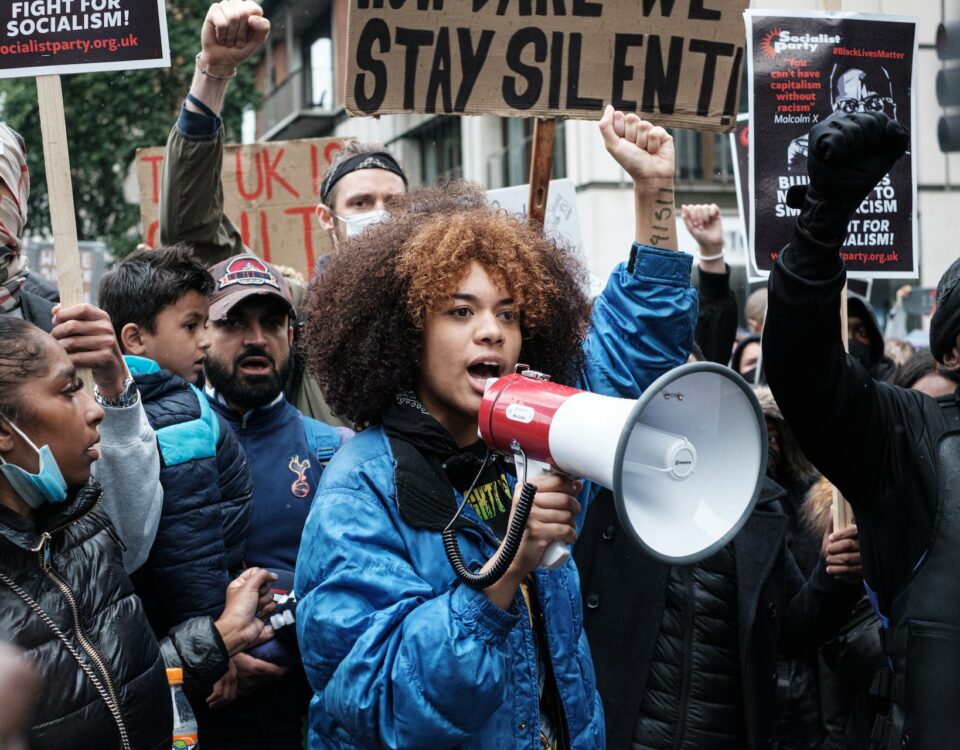 A woman is passionately holding a megaphone during a protest for human rights.