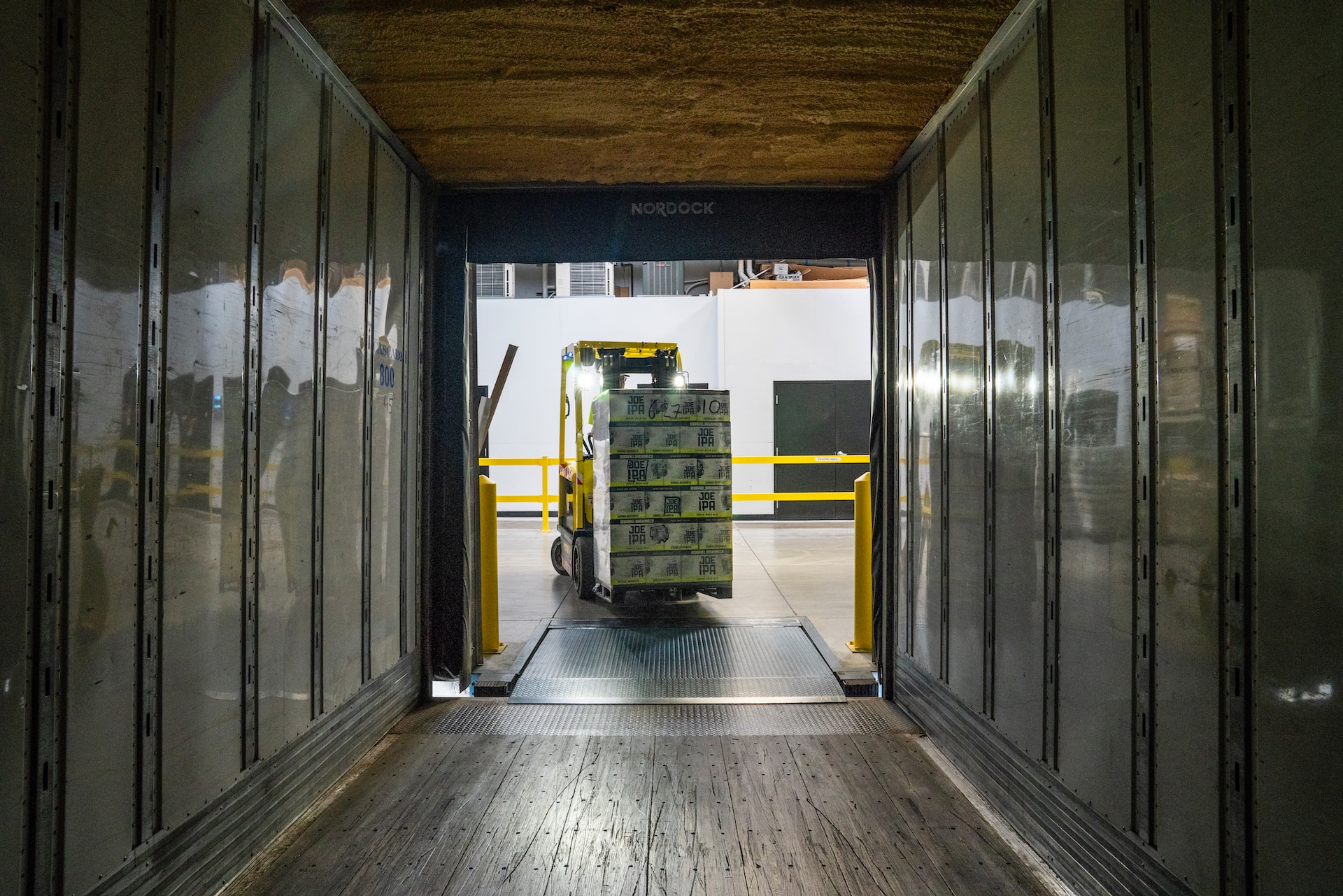 A forklift efficiently driving through a warehouse door, ensuring seamless logistics optimization.