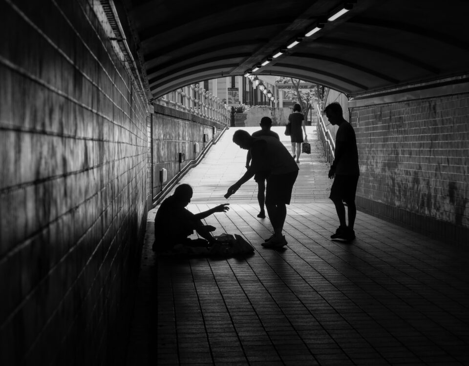 A black and white photo of a group of people in a tunnel, representing economic inequality.