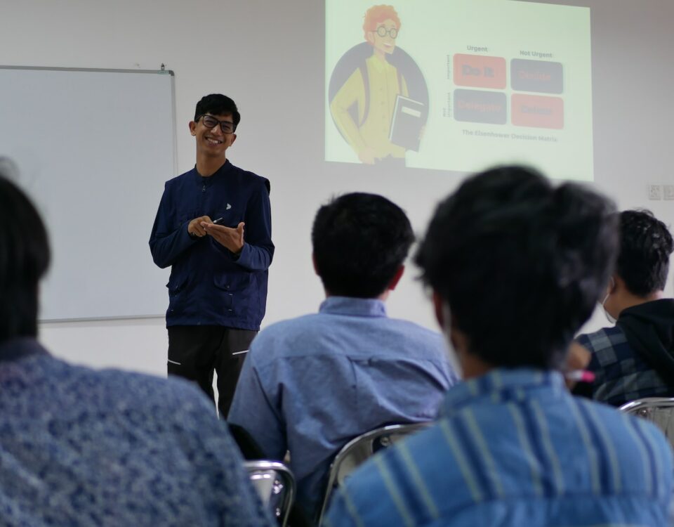 A man giving a presentation on International Trade to a group of people.