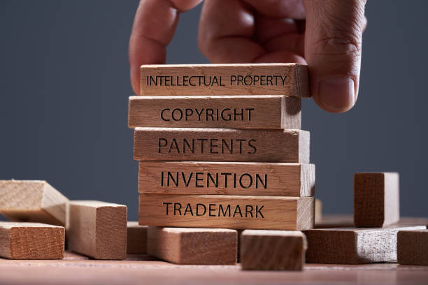 A person carefully stacking blocks with the words intellectual property and copyright, emphasizing the importance of intellectual property protection in foreign markets.