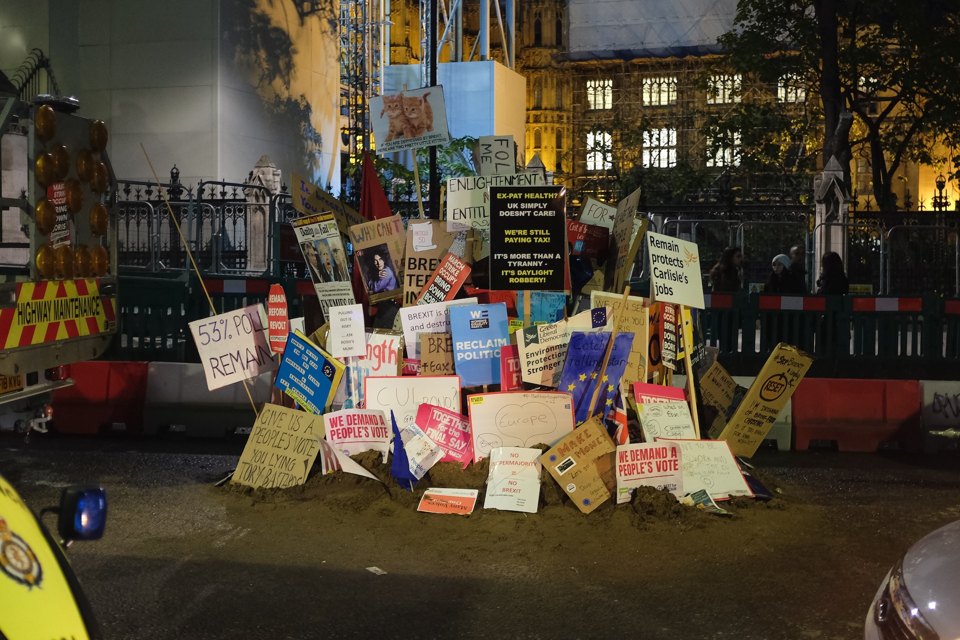A large pile of protest signs related to Brexit scattered in front of a building.