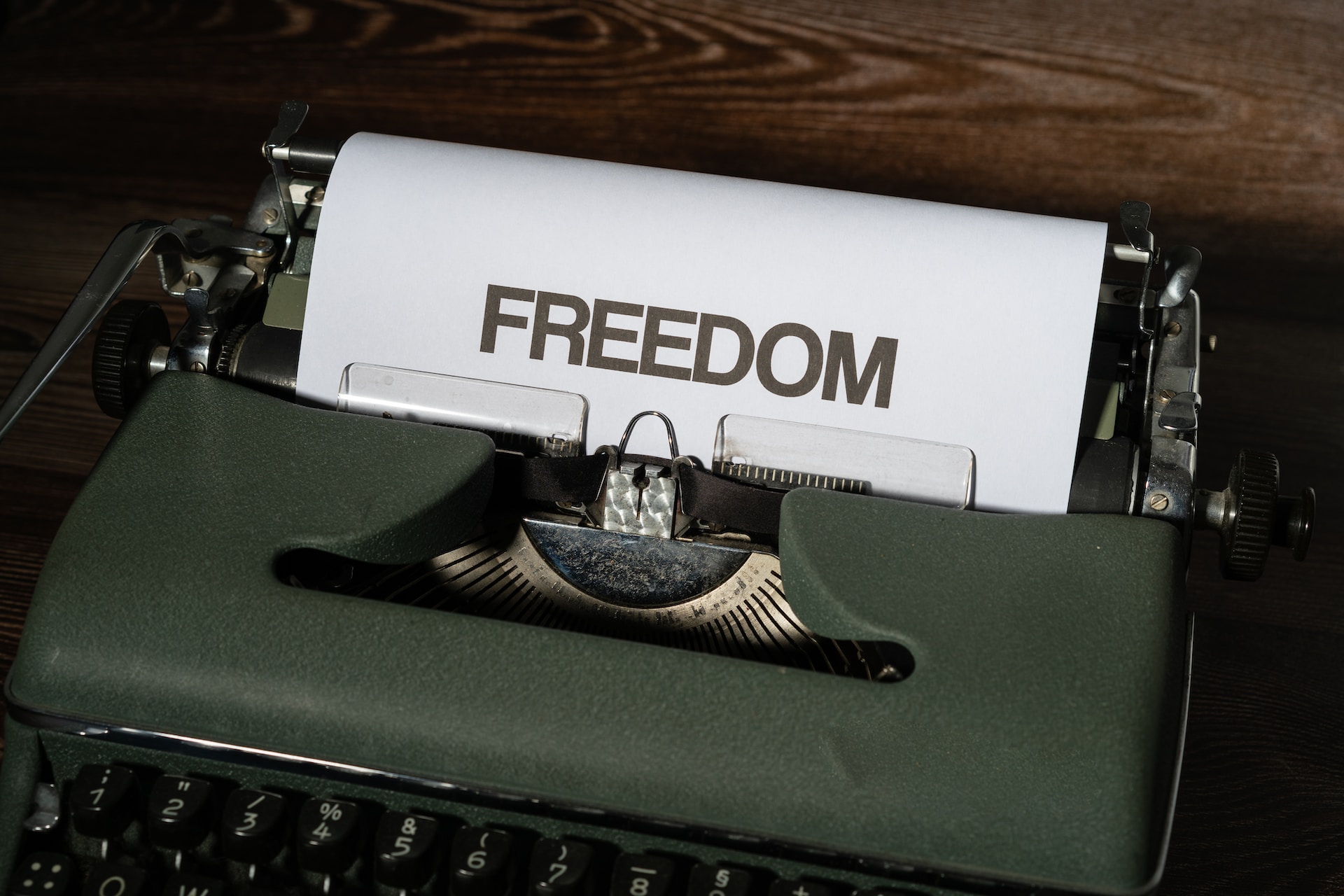 A green typewriter with the word freedom on it, symbolizing economic resilience.