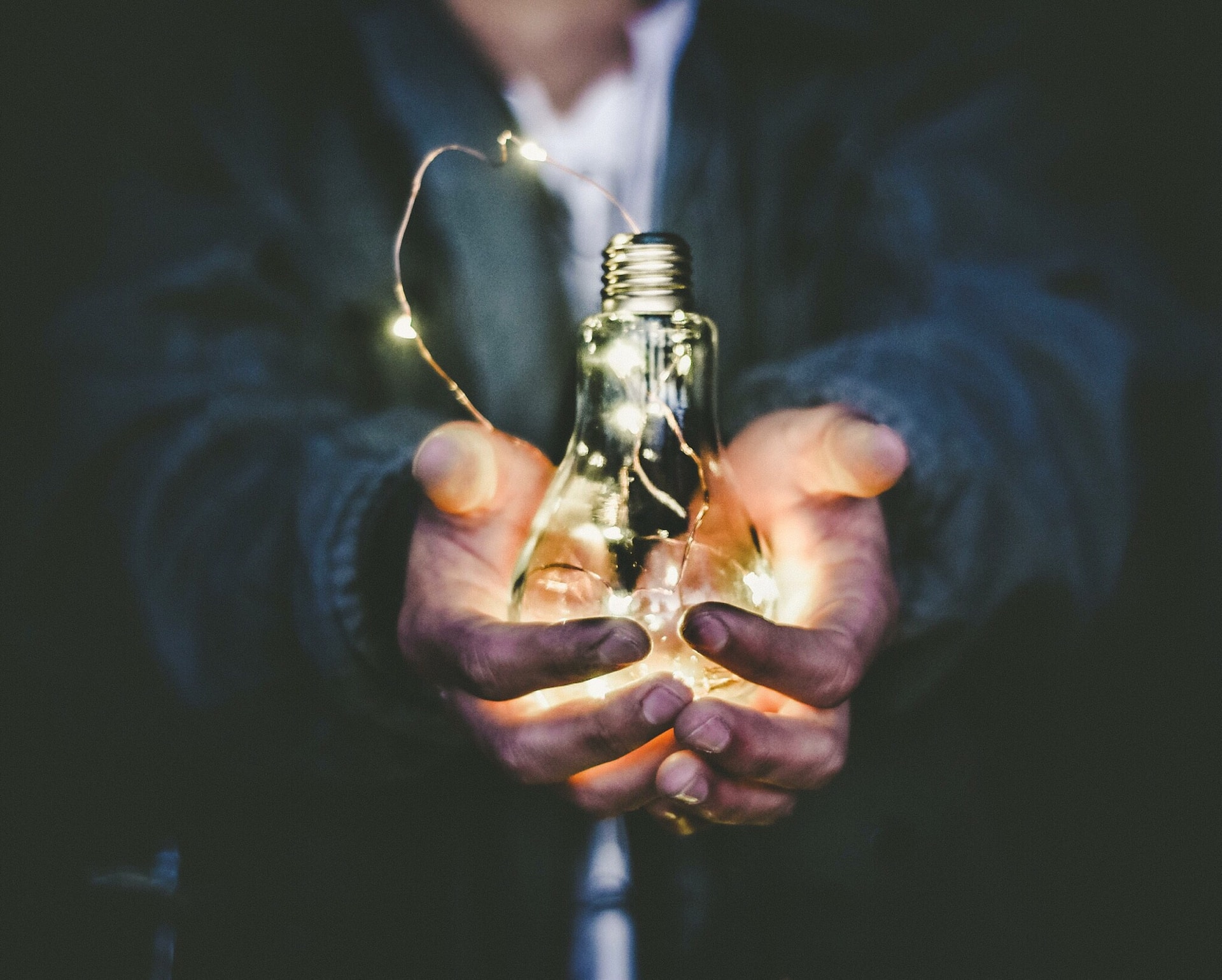 A person holding a light bulb, channeling their creativity to boost innovation in international trade.