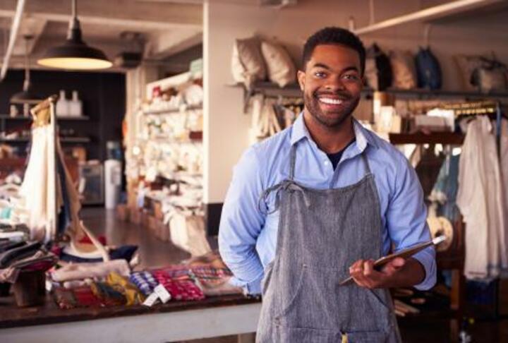 A man in an apron capitalizing on opportunities in a small and medium enterprise shop.