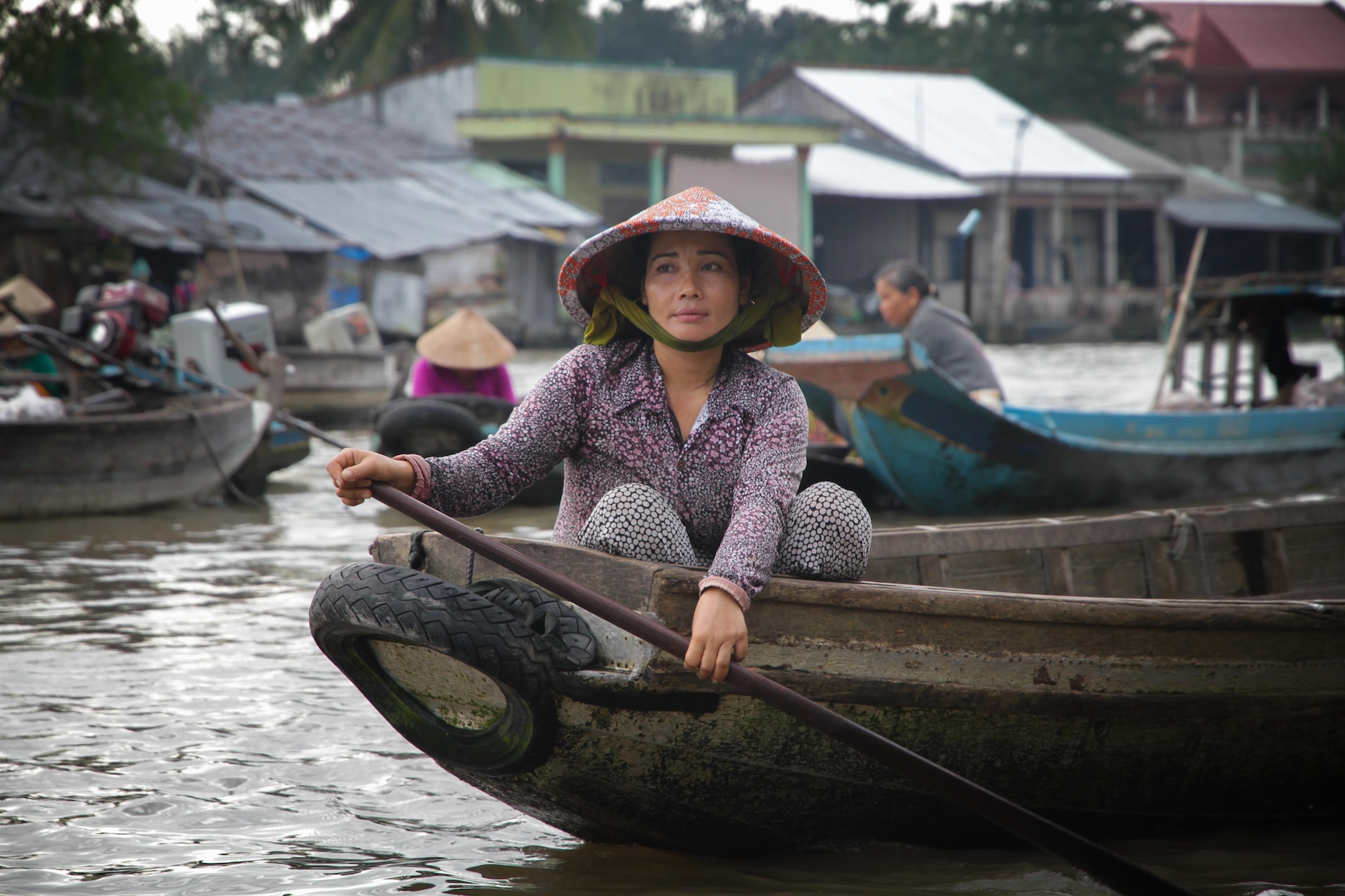 A woman demonstrating cultural intelligence while peacefully sitting in a boat on a river, engaging in cross-cultural communication.