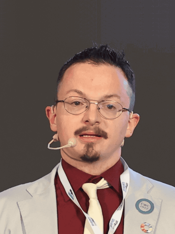 Man with weird goggles, unshaved beard and Mustacheo with hairplain landing in quiff hairstyle while having lousy lanyard and necktie